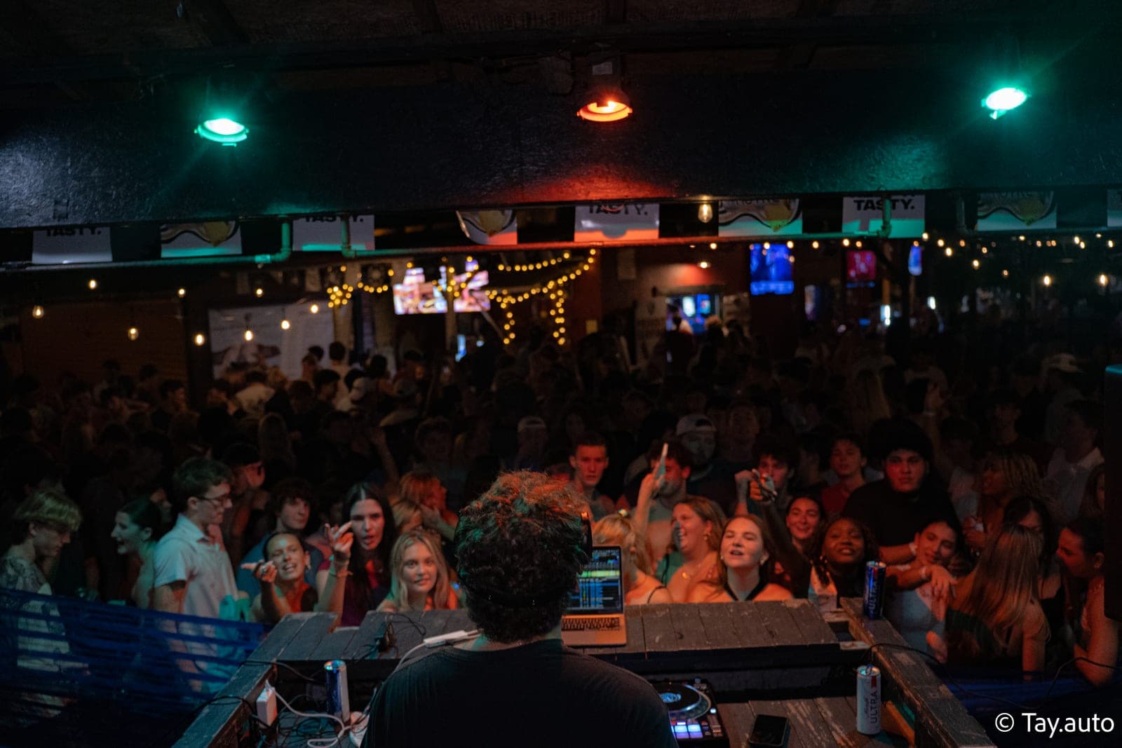 Packed indoor crowd under string lights during a club set